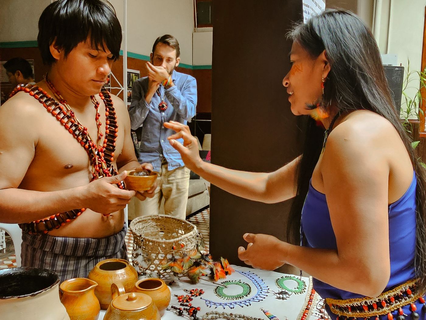 Miembros de la comunidad compartiendo bebida y artesanía con visitantes